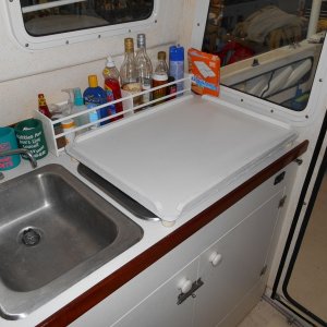 Made a tray that fits over the stove and expands the workspace when moved to the folded helm seat (see next pic).  Also note bottle holder behind tray made from dowels and 1/4" ply.