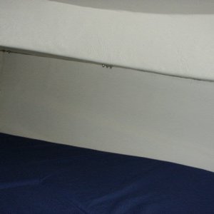 Cotton canvas (mildew resistant coating) glued to foam with 3M Super 77 spray adhesive. The more adhesive you use on this, the better the foam and cotton stick to each other and to the contours of the hull.