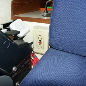 GFI mounted in plastic outlet box next to Captain's chair. Each GFI is connected to it's own breaker. Small speaker to the side of GFI is for VHF radio.