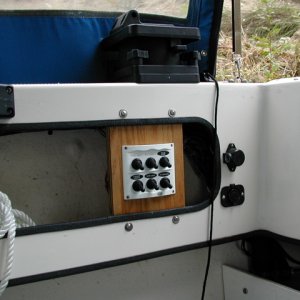(rogerbum) 6 switch electrical panel in cockpit.  Top L is Man Fore Bilge, Top C is Man Aft Bilge, Top R is Auto Aft Bilge, Bottom L is cockpit lighting (12V rope light to be installed), bottom C is SpotLight, bottom R is new 12V outlet (to right of panel, below downrigger power)