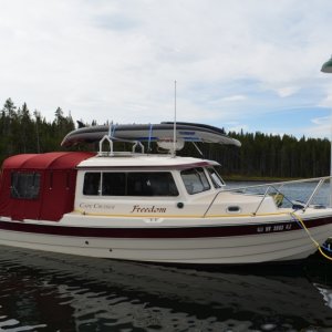 The kayak weighs a total of 32 pounds, spread between the rack and radar dome.  The bow section rests on the radar dome but does not touch the anchor light or VHF antenna.