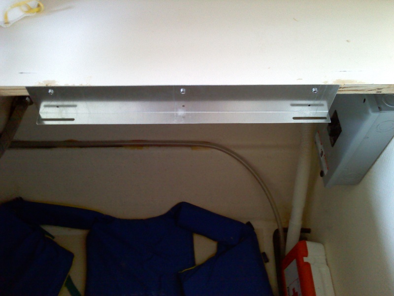 04/01/2010, bracket for cooktop, mounted flush with counter top, one each side, circuit breaker box mounted inside cabinet, visible to just right of bracket.