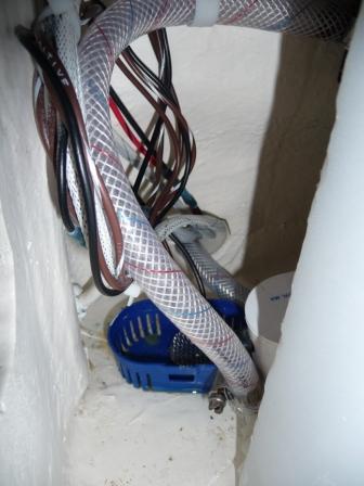 10. Wires and water line on the aft side of the water tank, on the port side, feeding into the white plastic chase under the cockpit floor.