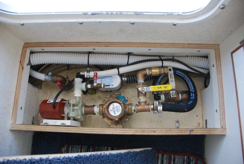 2013-07-26 view of A/C and head thru-hulls with new fresh water flush setup.
The large red handeled seacock valve is for the head. 
The small red handeled valve is for the system bleeder, for the circulating pump. 
The white handeled seacock valve is for the air conditioner. 
The yellow handeled valve is for the fresh water  inlet to the air conditioner.