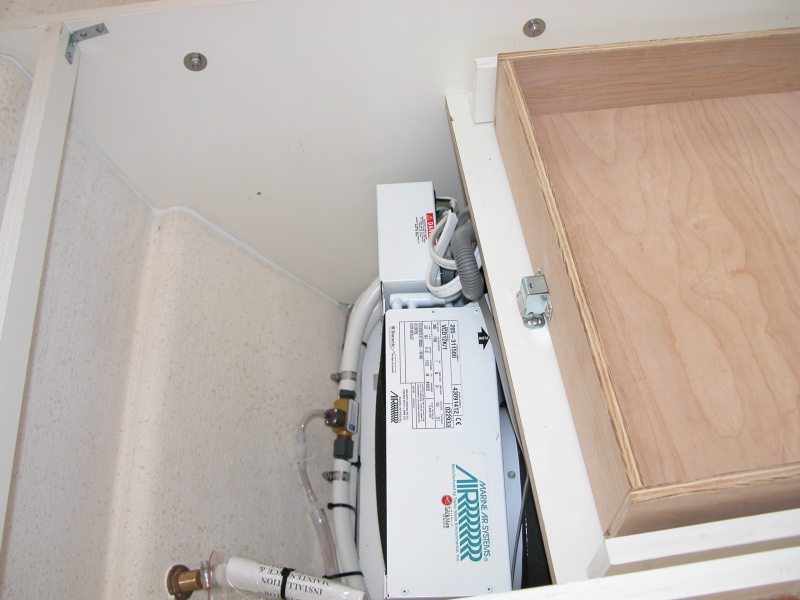 AC is located under mate's seat. The "T" in the cooling line is to drain the drip pan of any condensation buildup.