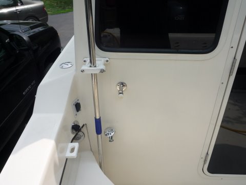 Added a faucet to my fresh water pump and tank.Just t'd off the output side of the fresh water pump. Easy to empty tank now can use for a cockpit shower. But the best is using it to wash down,the anchor chain or the scum line boat and brakes after retriving from salt water and even giving the motor a fast flush.We carry a rollup 50' hose to get water or use it for wash down purposes. Handy spot for our boat hook,gaff, net, scrub brush handle made by Slo lo marine. A short piece of pvc pipe which is 5200'ed to the floor keeps the bottom from moving around. My pliers holder for fishing expeditions is the rectangular block with th oval hole. Also the switch and outlet for my raw water washdown which we have elimanated the thru hull  and have a hose with a screened pickup which we put overboard connected to the pump for the raw water wash downs intake.