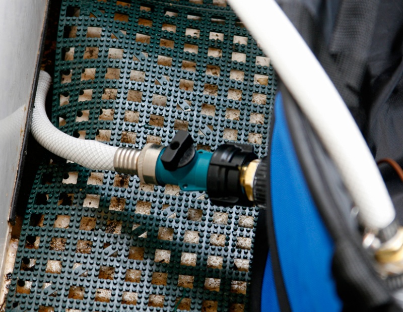 An ordinary garden hose coupling and cutoff valve is plumbed into the collapsible tub drain. The hose empties into the mid ships bilge and 1100 gph bilge pump empties the water overboard.