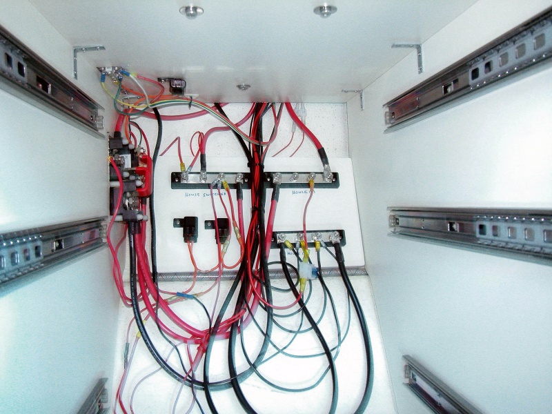 (AnchortownJim) Glued a piece of 3/4" marine plywood to the hull with 3M 4200.  Mounted the DC bus bars, one for the switched house circuits, one for non-switched and a common ground bus.  This was driven by the installation of the windless.