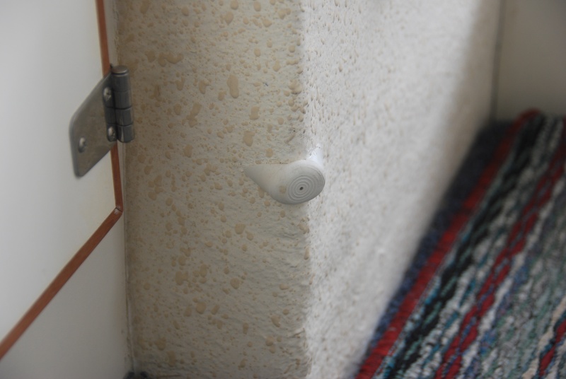 Bumper set with "5200" to protect cabinet door. 
As a side note: A fitted grey indoor/outdoor carpet is laid over fitted 'dry deck' panels and a colored(viewed) runner is placed on top. Each is very easy to remove,clean or replace.