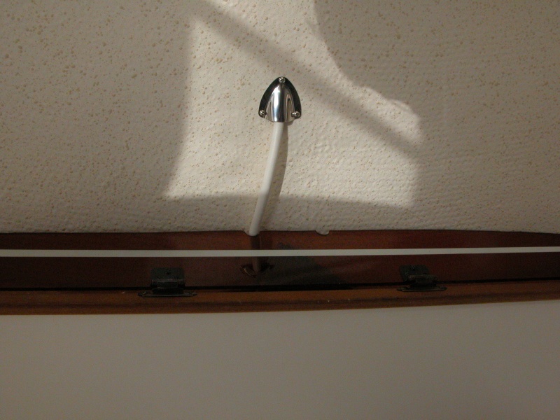 Cabin shelf viewed from below . The RADAR power cable is off center as it passes over the shelf. A second notch was equally placed off center to starboard as a finger hole to pull down and open the door.