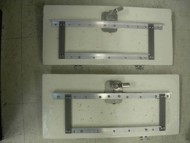 Cockpit hatch modification.  Angle brackets coupled to latch and hinges.  All components corrosion resistant.  Brackets preloaded to bend lid 1/8\" per Sea Skippers recommendation.  Bracket held with epoxy and wood screws.