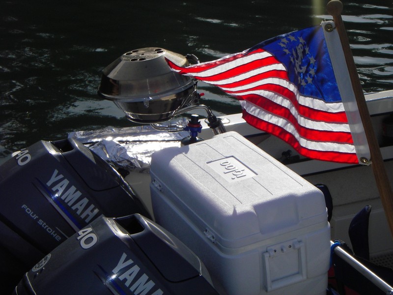 Combine these makings for a fine evening.  Yacht ensign on the back of a CD; a little power to get out on the water; a cooler with some staples; and a grill to fix it with.
