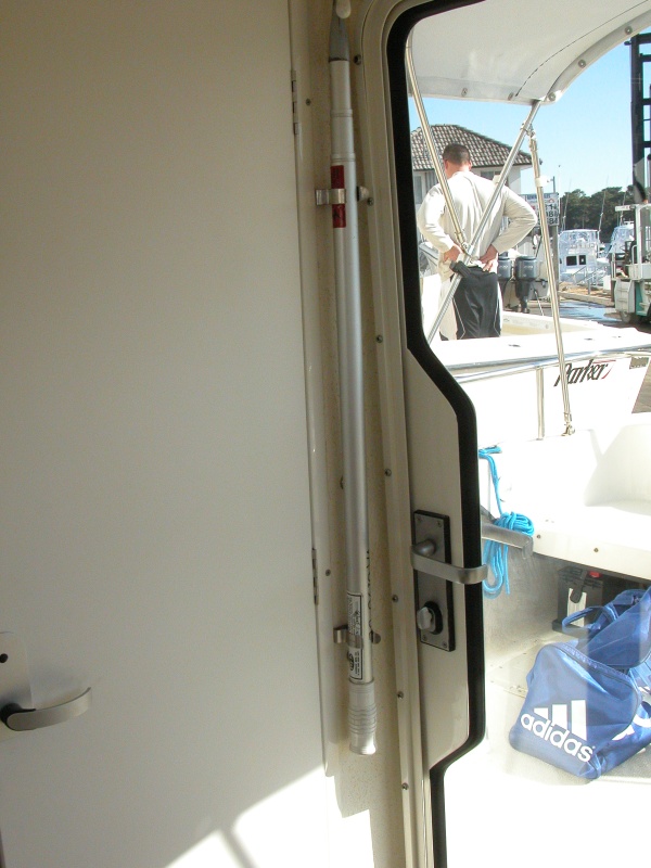 Convient and secure boat hook storeage easily accessibly from cockpit when door is open.