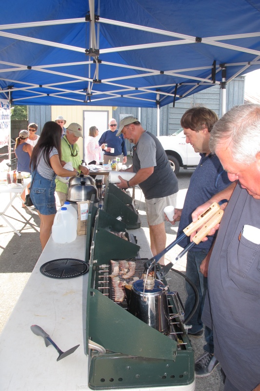 cooking tent - many hands make light work - pancakes, sausages, bacon on camp stoves