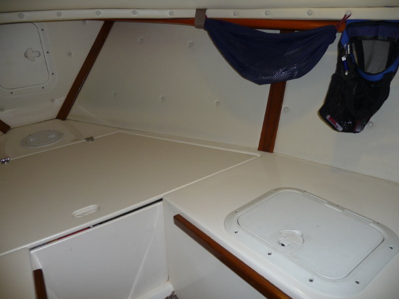 Cutty, forward to starboard.
Wooden boat paddle held up under port forward deck.
Access hatch to storage locker.