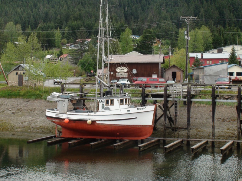 fishing boat on tidal grid getting new coat of bottom paint at Hoonah marina