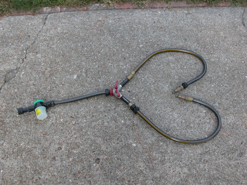 Flushing setup for use with twin HONDAs saves 20 minutes by doing both engines at once. Parts available at many hardware stores. The two adaptors on the end of the twin hoses are custom HONDA fittings. The Plastic white container is for the "SALT AWAY".