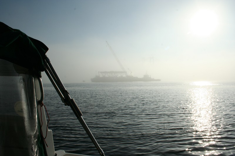 Fog lifts to reveal barge with deck section ready to lift