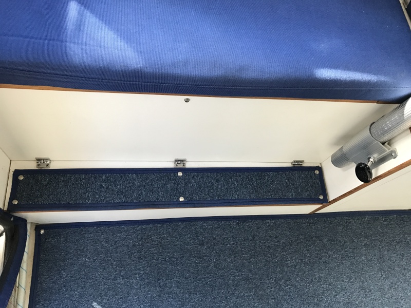 Foot rest in front of port bench seat with storage compartment underneath.