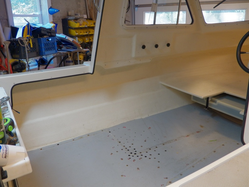 Here is the major damage.  This is too big of an area to fix by just cleaning out the holes.  I can get an idea of the area based on the pattern of the "black holes."  The second hole from the left (against the chine) is also black, and there was another single bad one on the starboard side.  One good thing, since I had the seat boxes and V berth posts out, I put in a permanent 23 gallon gas tank (visible under the berth).  I'll start another album for that.