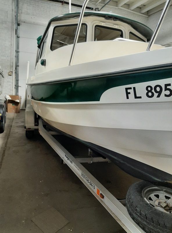 Home in Winter storage Wilson, NY.  My marina guys did an awesome job restoring gel coat and forest green stripe.