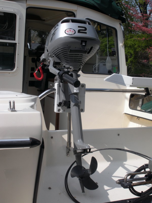 Honda 2 HP outboard in place.  I will attach a 6x6 piece of starboard to the base of the splashwell below the OB skeg with screws to prevent damage.