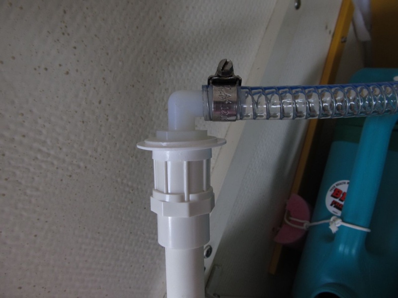 I drilled a hole in the cap and fit a nylon elbow into it from above.  It's 1/2" barb (hose end) to 1/2" male NPT (end that goes through the cap).  That threads into a PVC fitting that is 1/2" female NPT on top, and a meant-to-be-glued socket on the bottom that fits the OD of 1/2" PVC pipe.  No need to glue as it's a tight friction fit.