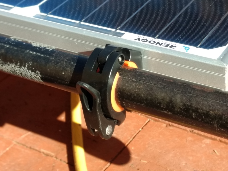 I used these cool little quick release clamps I found on Amazon. They're actually bicycle handlebar clamps to mount a flashlight.

This makes it easy to swap the panel to the roof rack on the truck when we want to go out boonie crashing.