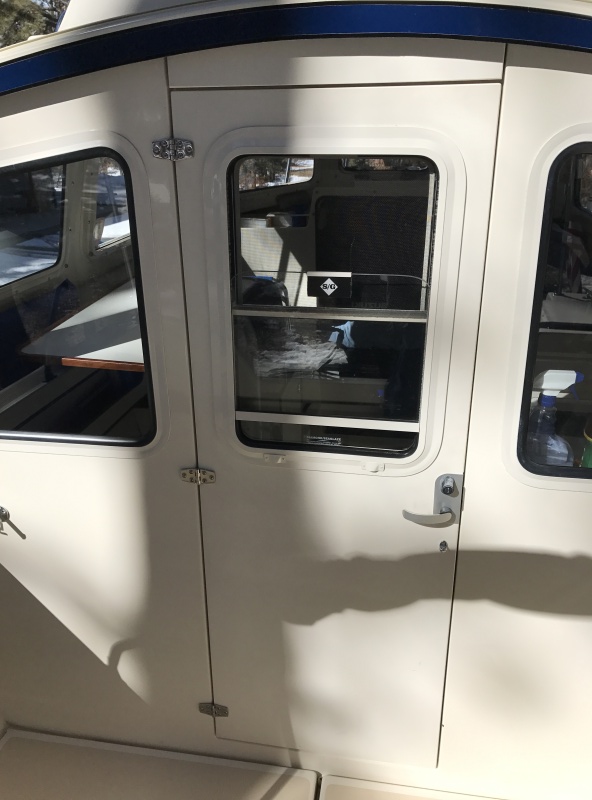 Locking cabin door has sliding window and screen.
