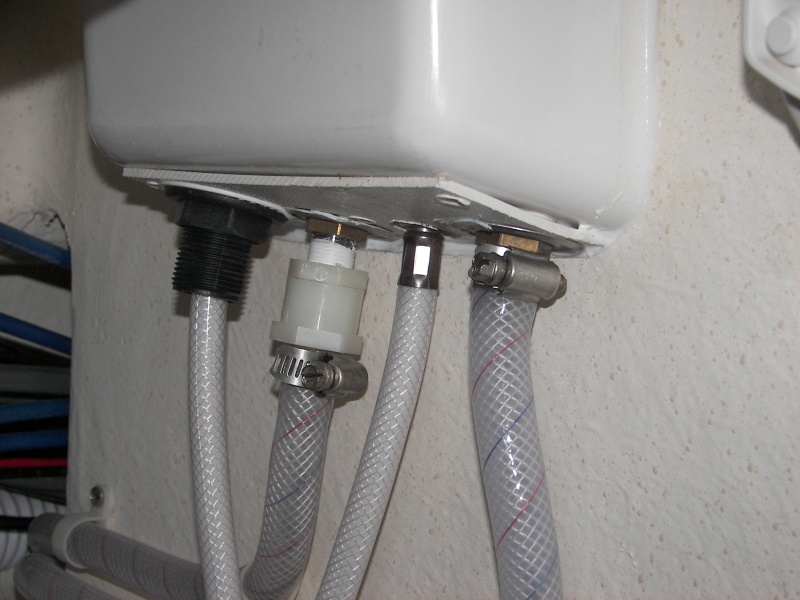 Long nylon fitting kept pulling off center, causing leak. Finally just heated the hose and clamped it directly to the shower hot faucet input threads. The back, left shows the original nylon fitting on the cold faucet. The back, right shows the hose clamped directly on the hot water faucet threads. No leak now!