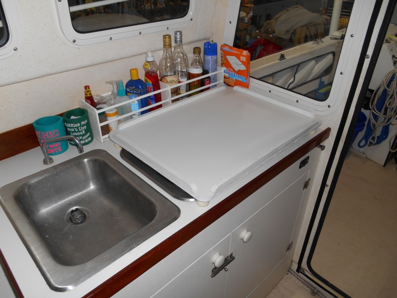 Made a tray that fits over the stove and expands the workspace when moved to the folded helm seat (see next pic).  Also note bottle holder behind tray made from dowels and 1/4" ply.