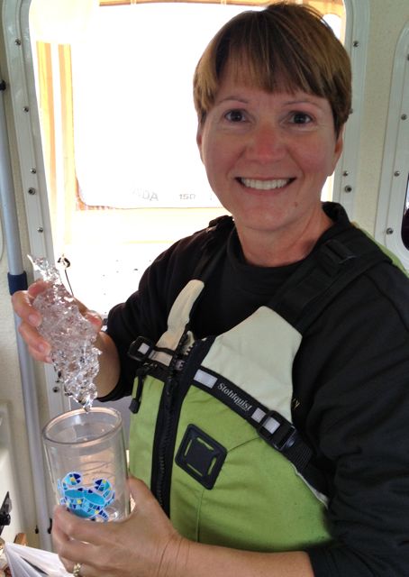 Mary about to cool her drink with a "bergie bit".