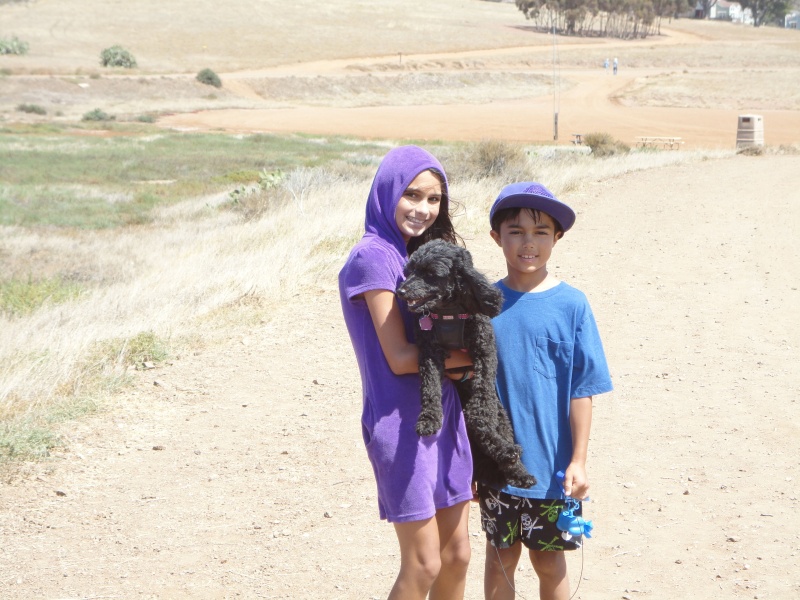 Maya Raval and Devin Raval carry miss Angel (thisaway boat dog)