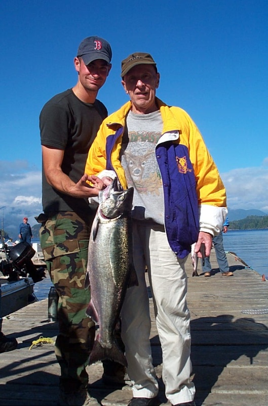 Middle son helping grandpa hold his last fish.