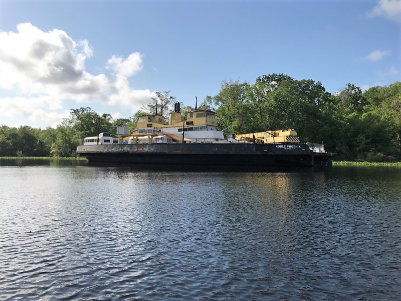 Noble Phoenix in Murphys Creek. Notice the AirStream trailer and two city buses on it\'s decks.