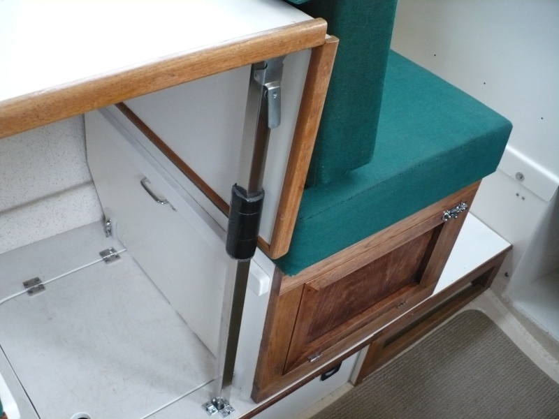 Note: The storage hatch cover Hinge was moved to the left so the box can slide back and a tab was added inside the hatch to support the lid. Also, I used some left over latch parts on the floor, this keeps the table leg from sliding backward. Also added a pad on the leg for the table to rest against.