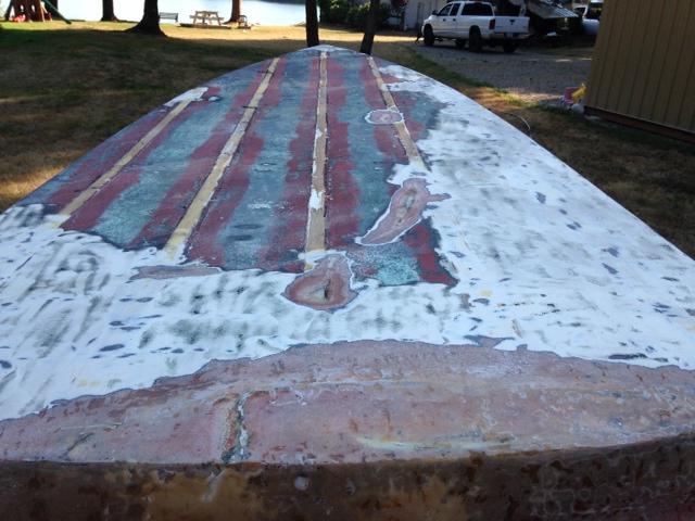 partially stripped bottom paint, angle grinder 50 grit disc.  Transom shows previous bad repair.