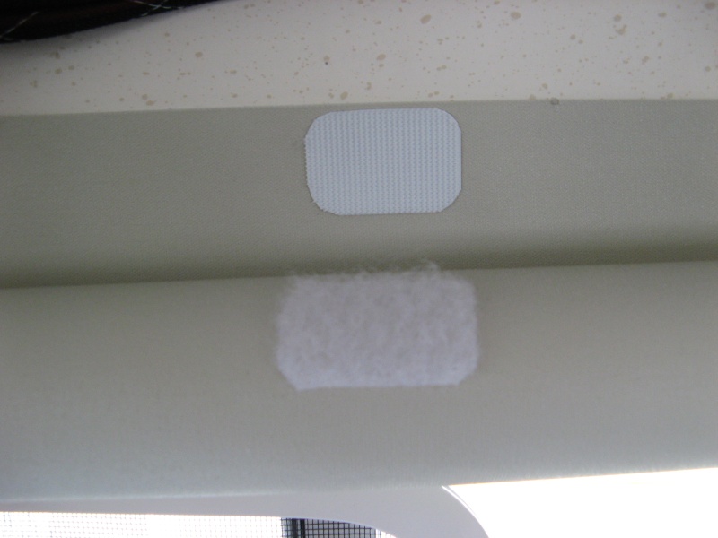 piece at top edge meets rolled shade to hold it up out of the way