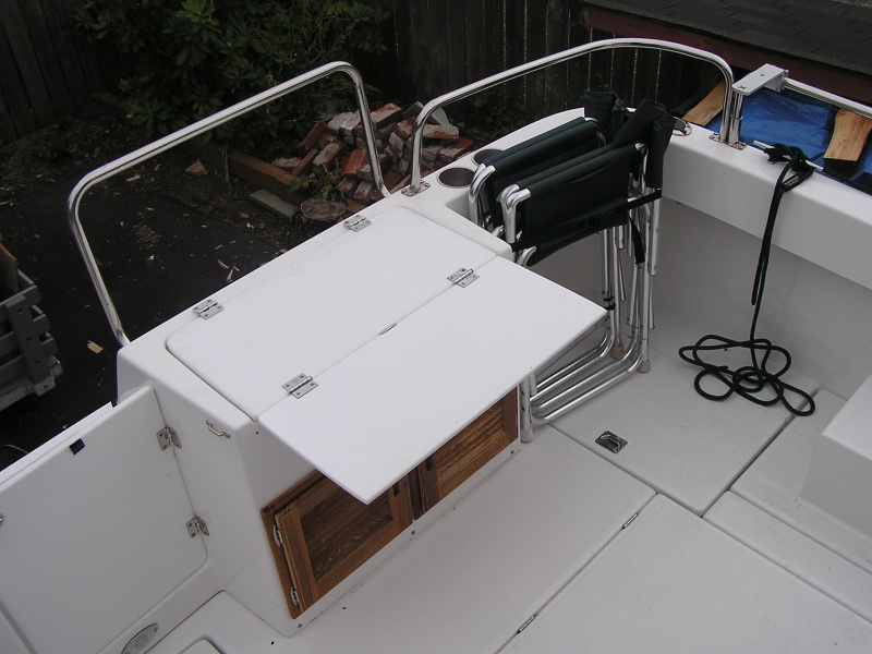 Removed cushion, added fold out table that is support with hinged bracket, added tie down brackets to hold folding chairs. Velcro on transom door keeps it open when needed