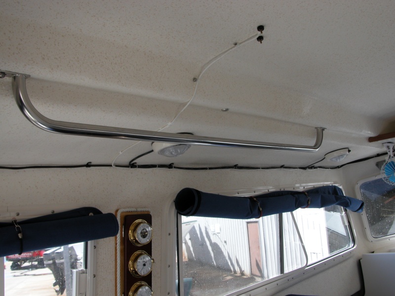 (Sea Angel) Port Side Grab Rail with factory window covers rolled up and held with small bungie cords.
Note WX Station between port windows and variable speed fan above Mate's seat.