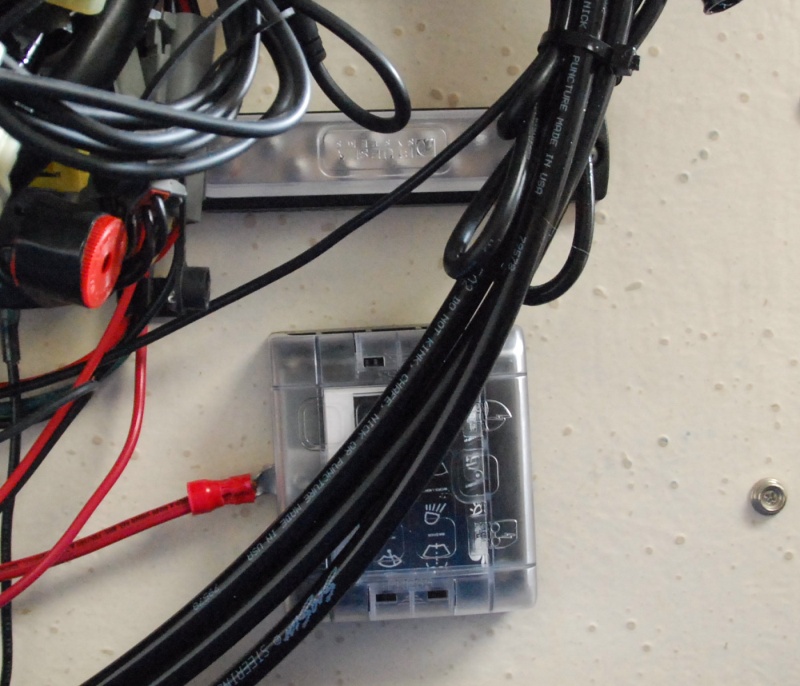 Sea Angel\'s Secondary AUX 6 ckt DC power block & 10x ground buss 1. The square block is the 12VDC Secondary AUX 12 VDC ATC fuse holder type Power Panel without ground strips and quick connect 'tabs' for the loads. 
The other end of red lead is connected to the 12VDC input connection (stud) of the Main Aux, 12 ckt  fuse panel w/ ground strips.