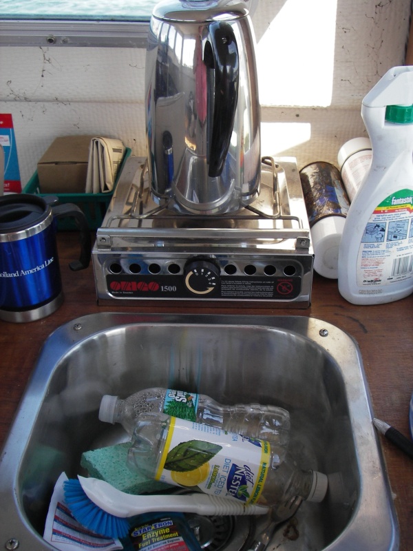 Shot of galley showing sink and stove behind it. Storage under stove.