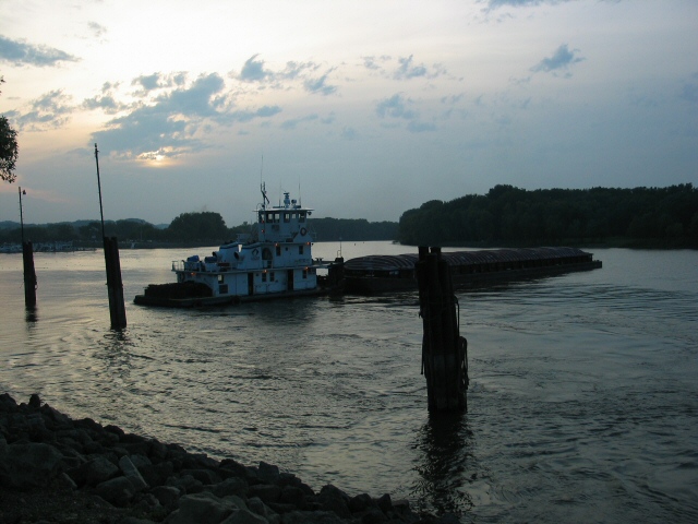 Small tow with single barge at dusk