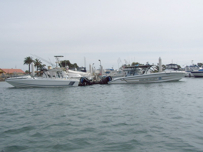 (Sneaks) They heard we were gathering in San Diego bay and prepared. Two Homeland Security fast boats. One marked, the other "unmarked"