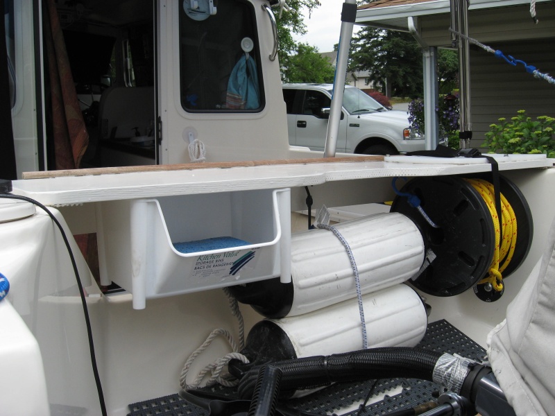 splashwell table stores 2 extra fenders, stern line and small locker.  All attached to table no holes.  Bungee to splashwell front  Off in no time if needed.