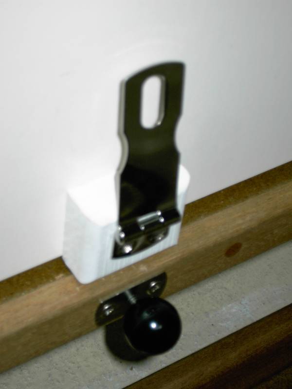 Stainless hasp with TyBoo gizmo below with the locking knob in place. Knobis counter sunk into edge of new floor and hasp is on seat face.