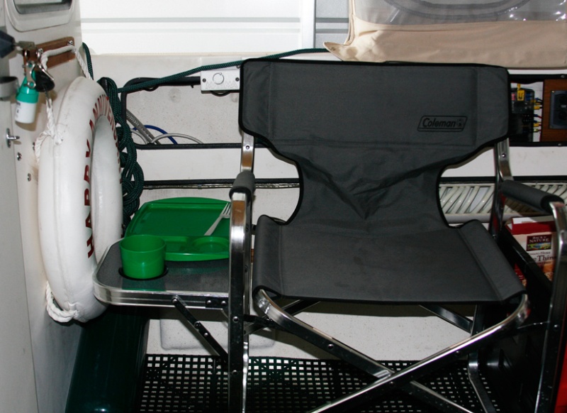 Starboard side view of Coleman chair with fold down side table. Life ring on the rear cabin bulkhead is ready to grab.