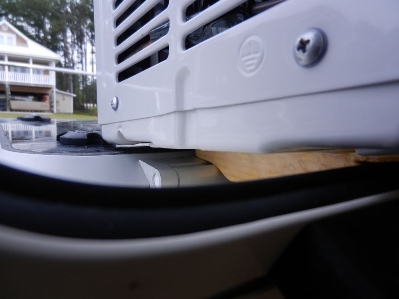 The backs of the "feet" are cut so that they sit on the hinges of the hatch.  They are cut down so that they cause the AC to angle back for good water drainage.  They are just high enough, though, to keep the AC off of the lexan.