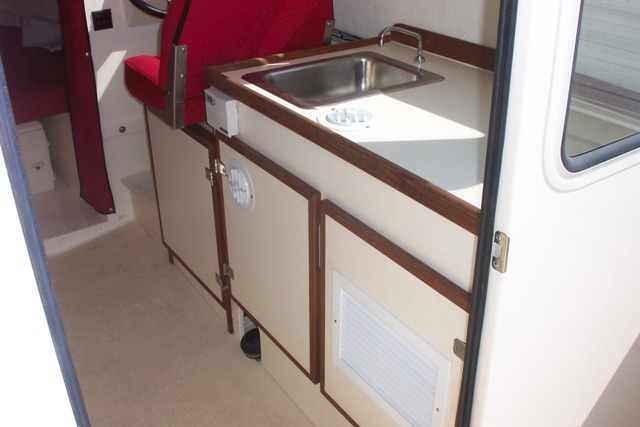The Mermaid Marine AC (www.wrightmarine.net) works great!  Craig hooked it up and we run it with a Honda 1000 generator, or shore power, either one.  Note the return air vent and two cool air vents.  The cabinet door can be opened to direct the air into the bed area.