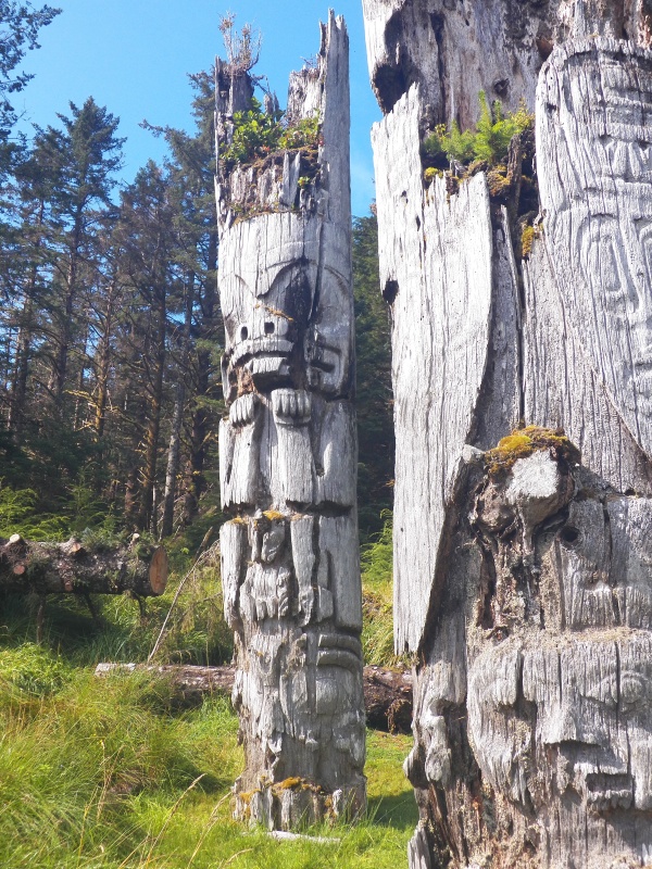 The mortuary poles are distinguished by being "upside down" with the thicker part of the tree at the top.  That allows for more room for the cavity holding the deceased persons bones and belongings (all of which was pilfered long ago).